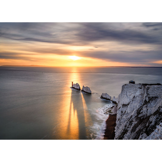 Sunset over a calm sea with chalk cliffs and a rock formation in the foreground on the Isle of Gascoigne captured by The Needles from Available Light Photography.
