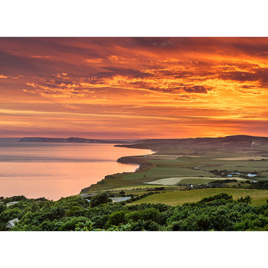 Coastal landscape at Sunset over West Wight, with fiery skies over rolling green hills and calm sea by Available Light Photography.