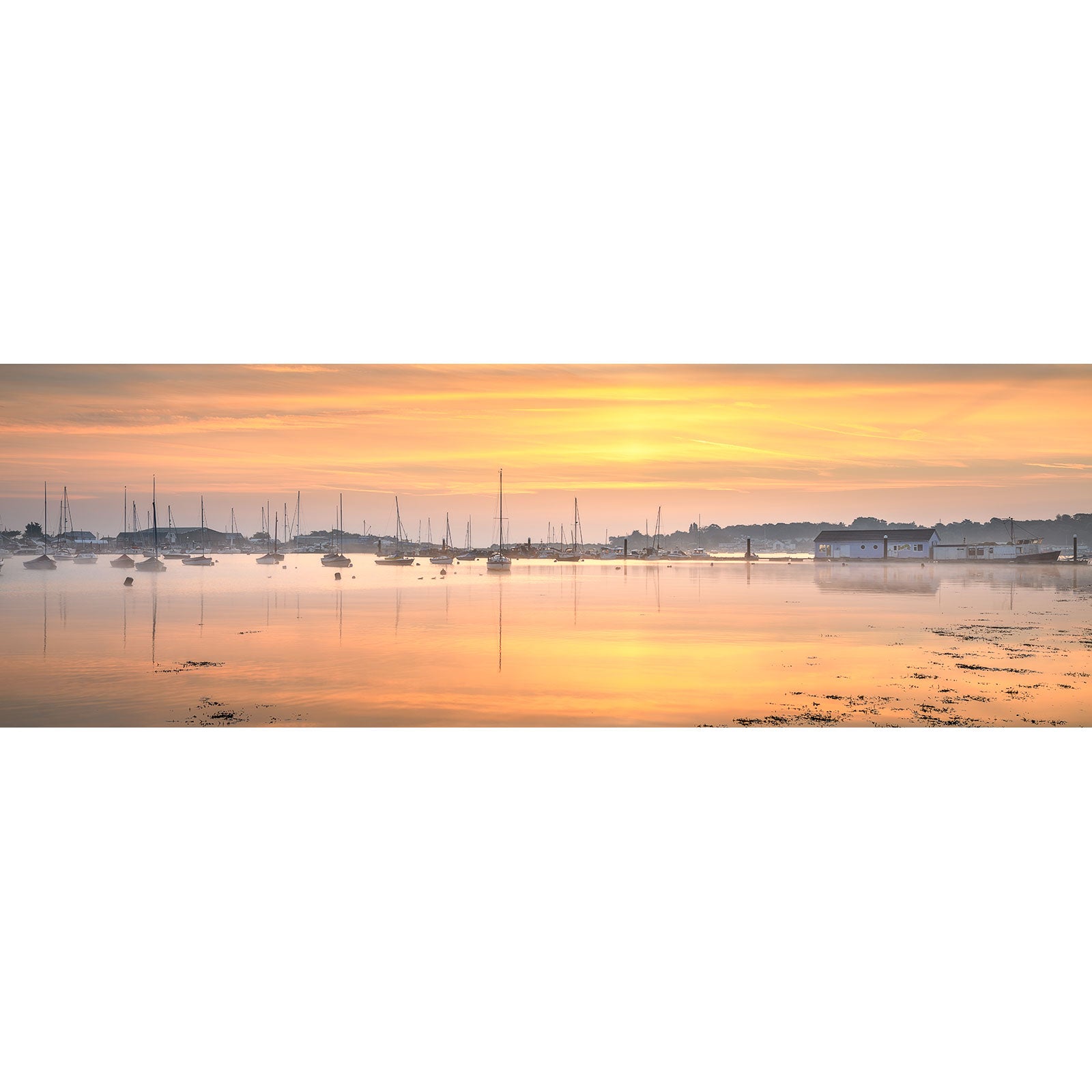 Sunrise over Bembridge Harbour with boats and reflections on the water on the Isle of Wight by Available Light Photography.
