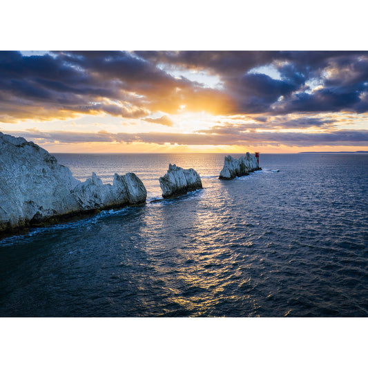 Sunset over ocean with rays of light illuminating cliffs on the Isle of Wight captured beautifully by The Needles from Available Light Photography.
