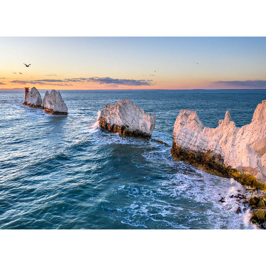 Sunrise illuminating The Needles white chalk cliffs on the Isle of Wight by the sea with birds in flight captured by Available Light Photography.