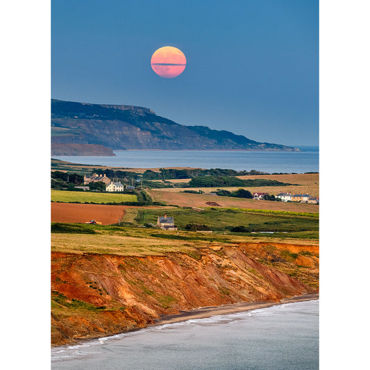A Moonrise over Compton Bay rising over a coastal landscape at Isle Gascoigne at dusk by Available Light Photography.