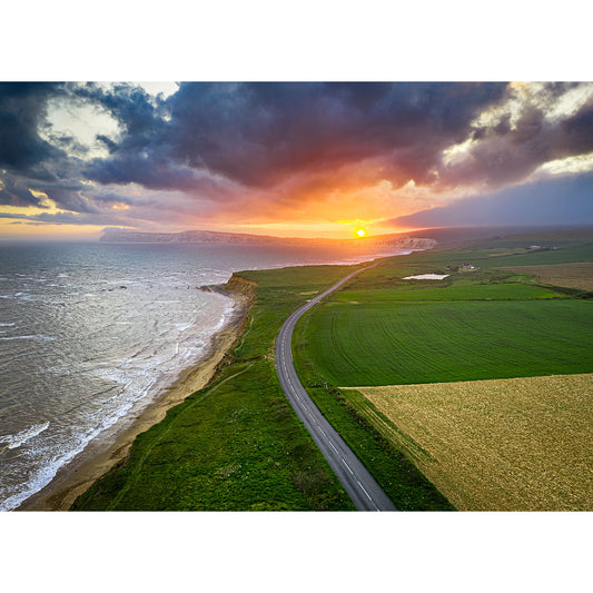 Aerial view of Compton Bay coastal road on the Isle of Wight at sunset with green fields on one side and the sea on the other, captured by Available Light Photography.