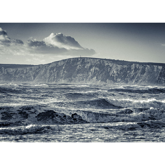 Rough sea with Stormy Waves at Compton in the foreground and a cliff in the background under a cloudy sky on the Isle of Wight by Available Light Photography.