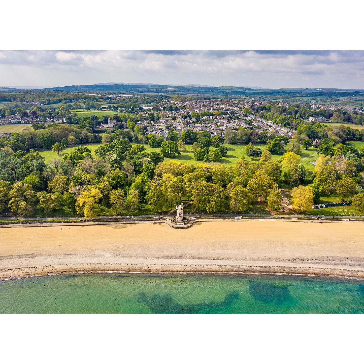 Aerial view of a coastal town on the Isle of Wight with Appley Tower near the beach, surrounded by greenery, captured by Available Light Photography.