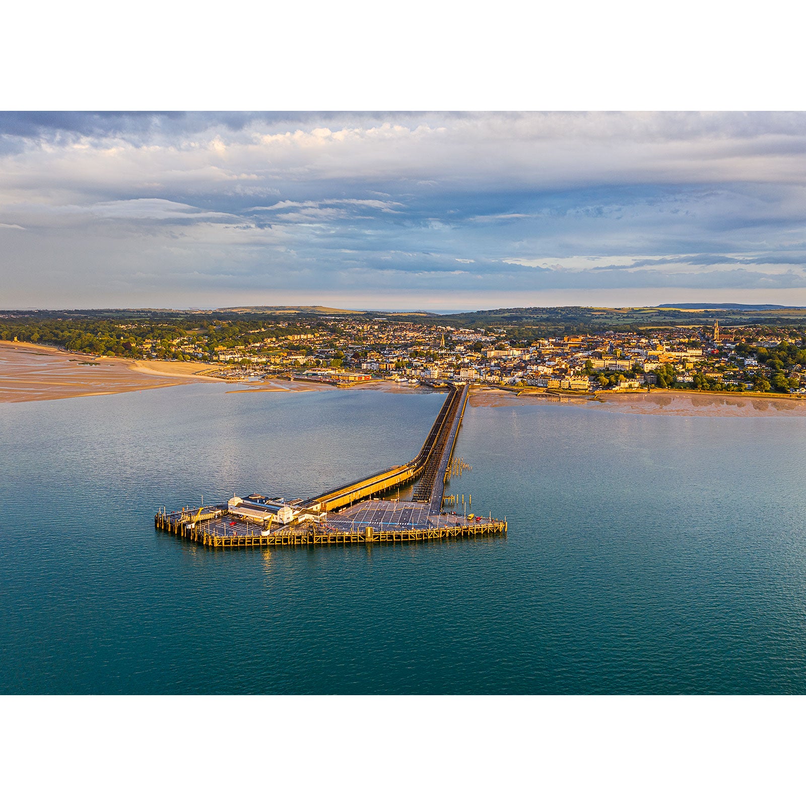 Aerial view of Ryde, a coastal town on the Isle of Wight with a long pier extending into the sea, captured by Available Light Photography.
