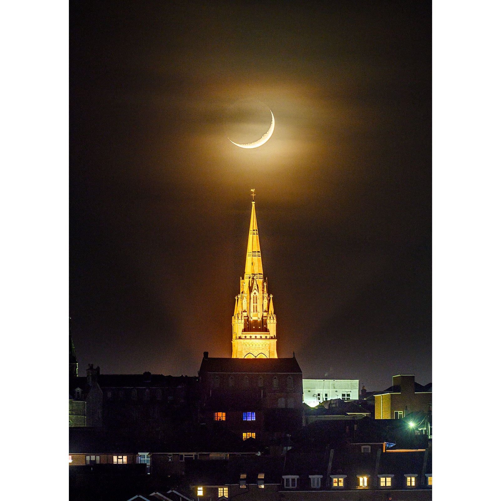 Crescent Moon over All Saints' Church, Ryde aligned above a lit church spire on the Isle of Wight during nighttime. (Available Light Photography)