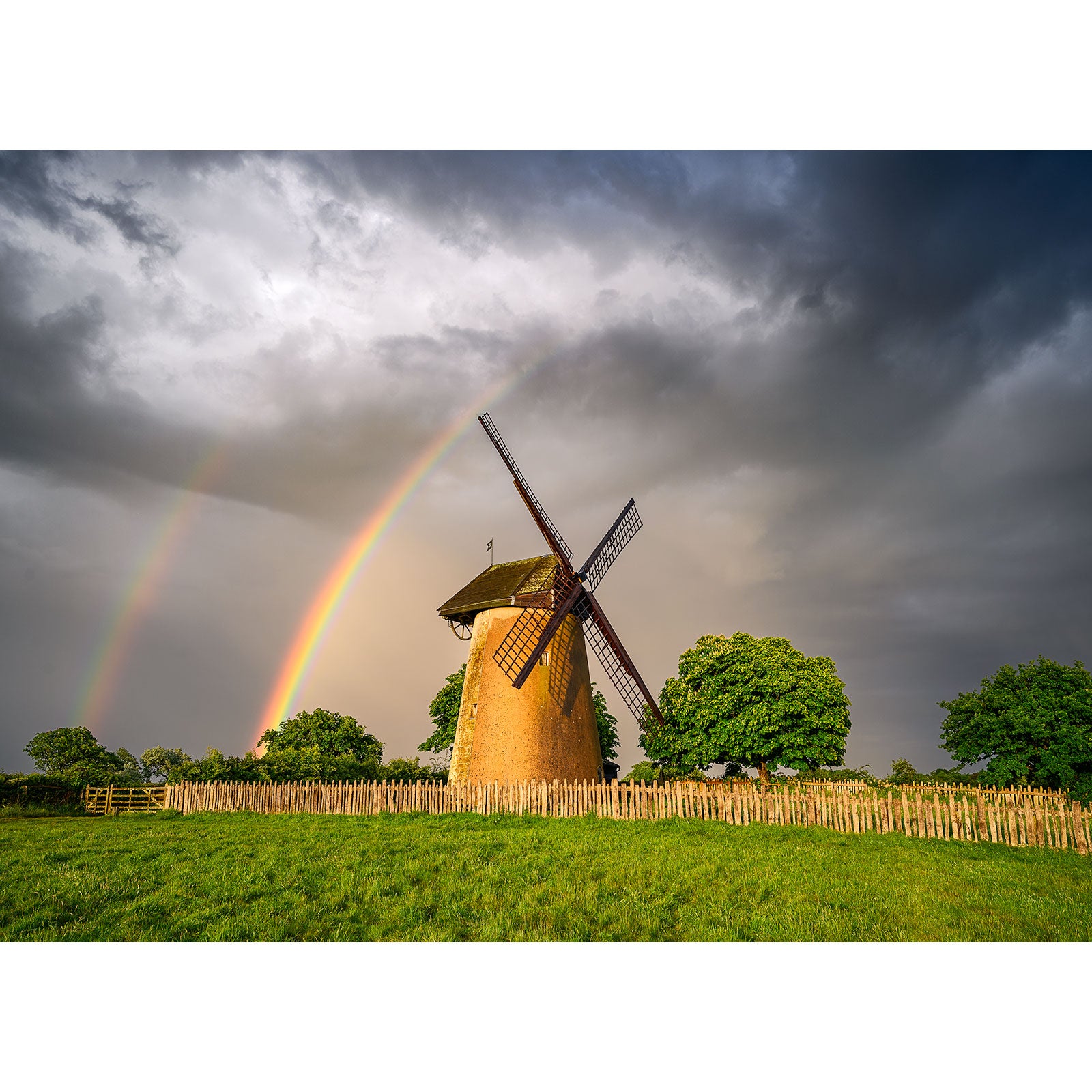 Bembridge Windmill on the Isle of Wight with a double rainbow in the stormy sky, captured by Available Light Photography.