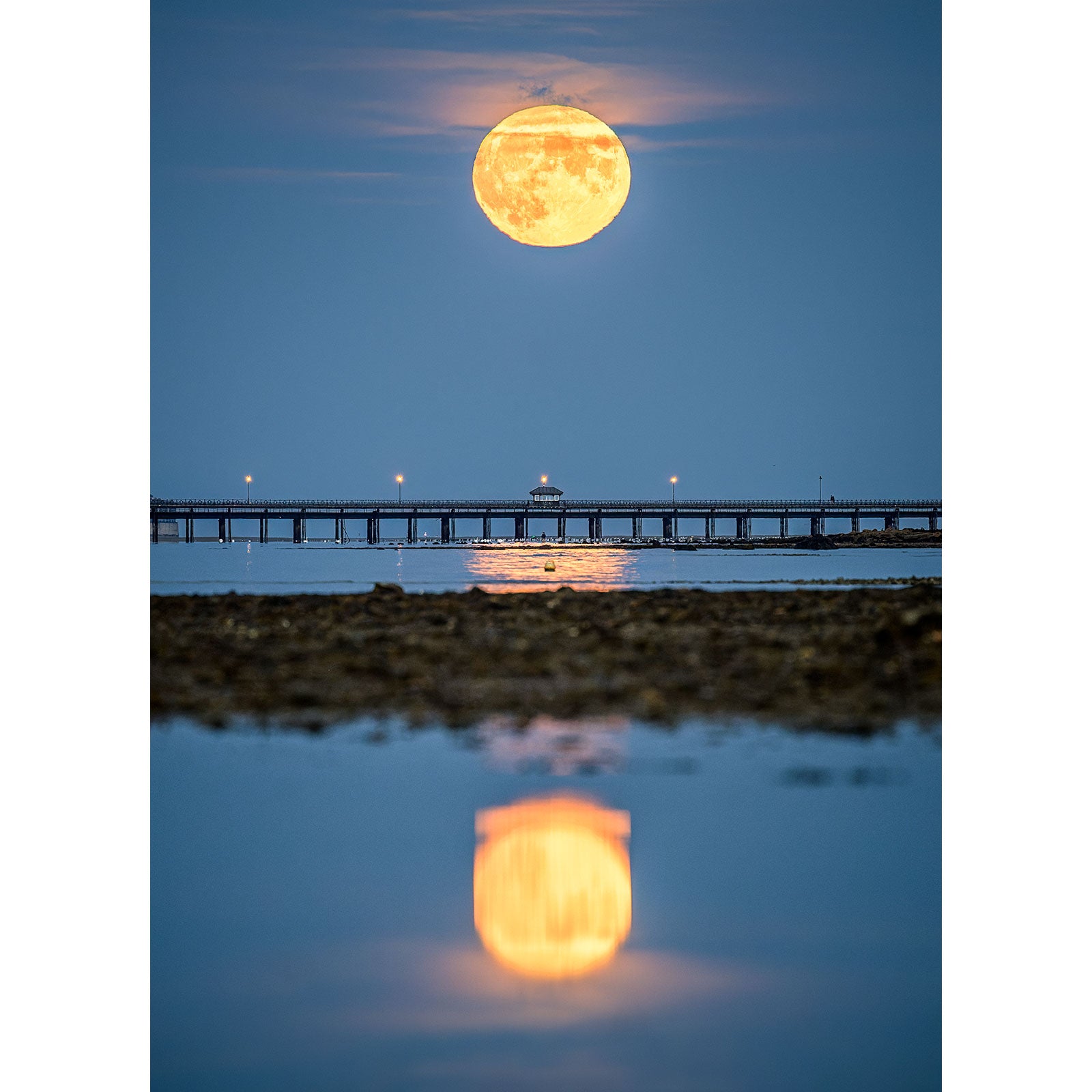 A Moonrise, Ryde Pier aligns perfectly above a pier, with its reflection highlighted in the water below, as Steve Wight captures the moment with Available Light Photography.
