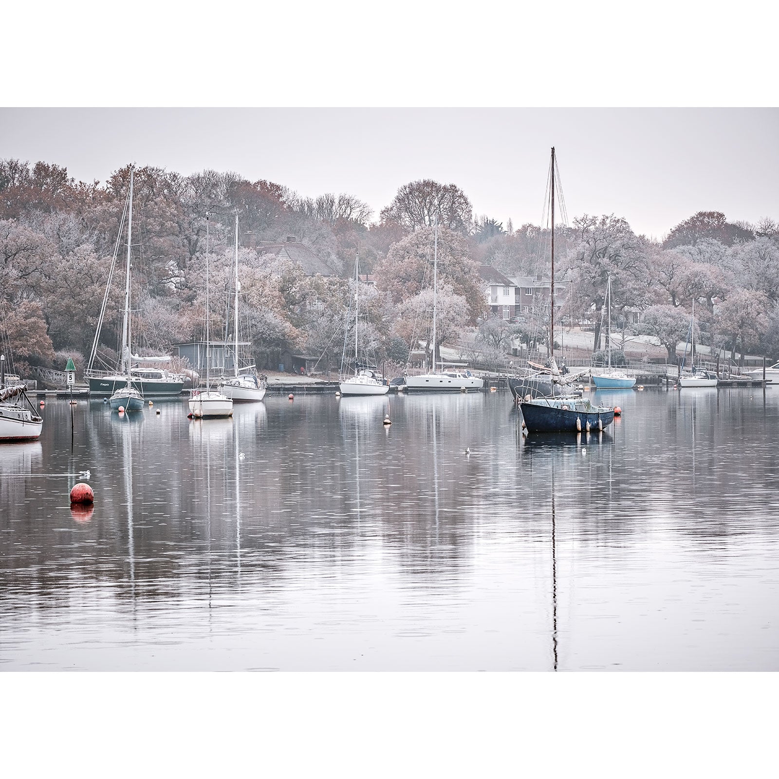 Tranquil Wootton Creek on the Isle of Wight on a misty morning with moored sailboats and bare trees captured by Available Light Photography.